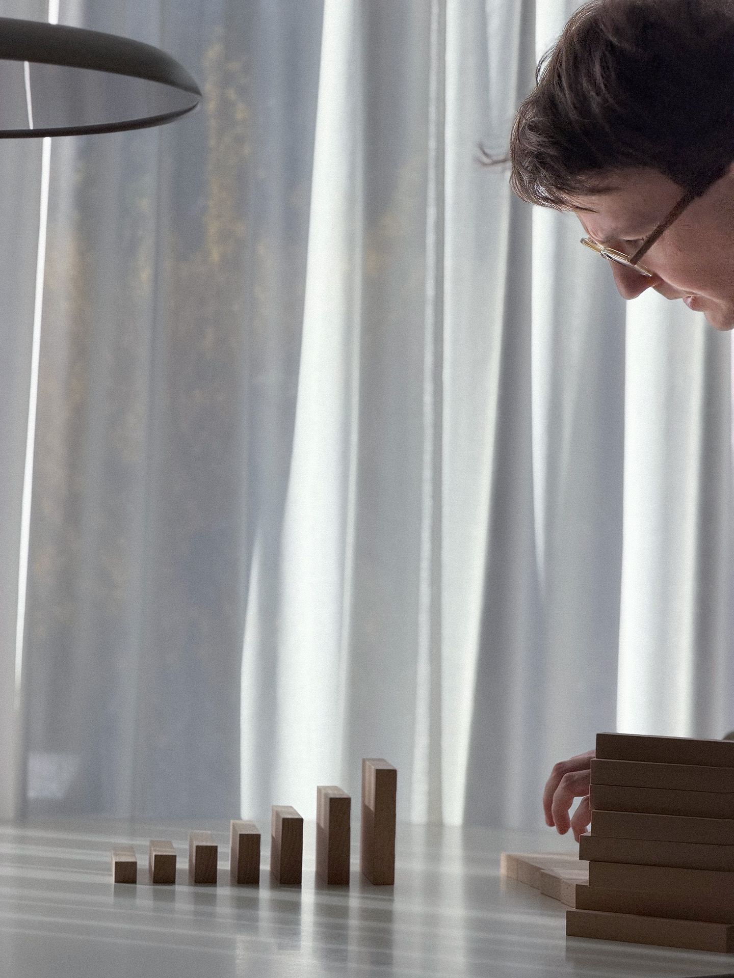 Hand exploring a sequence of upright wooden blocks.