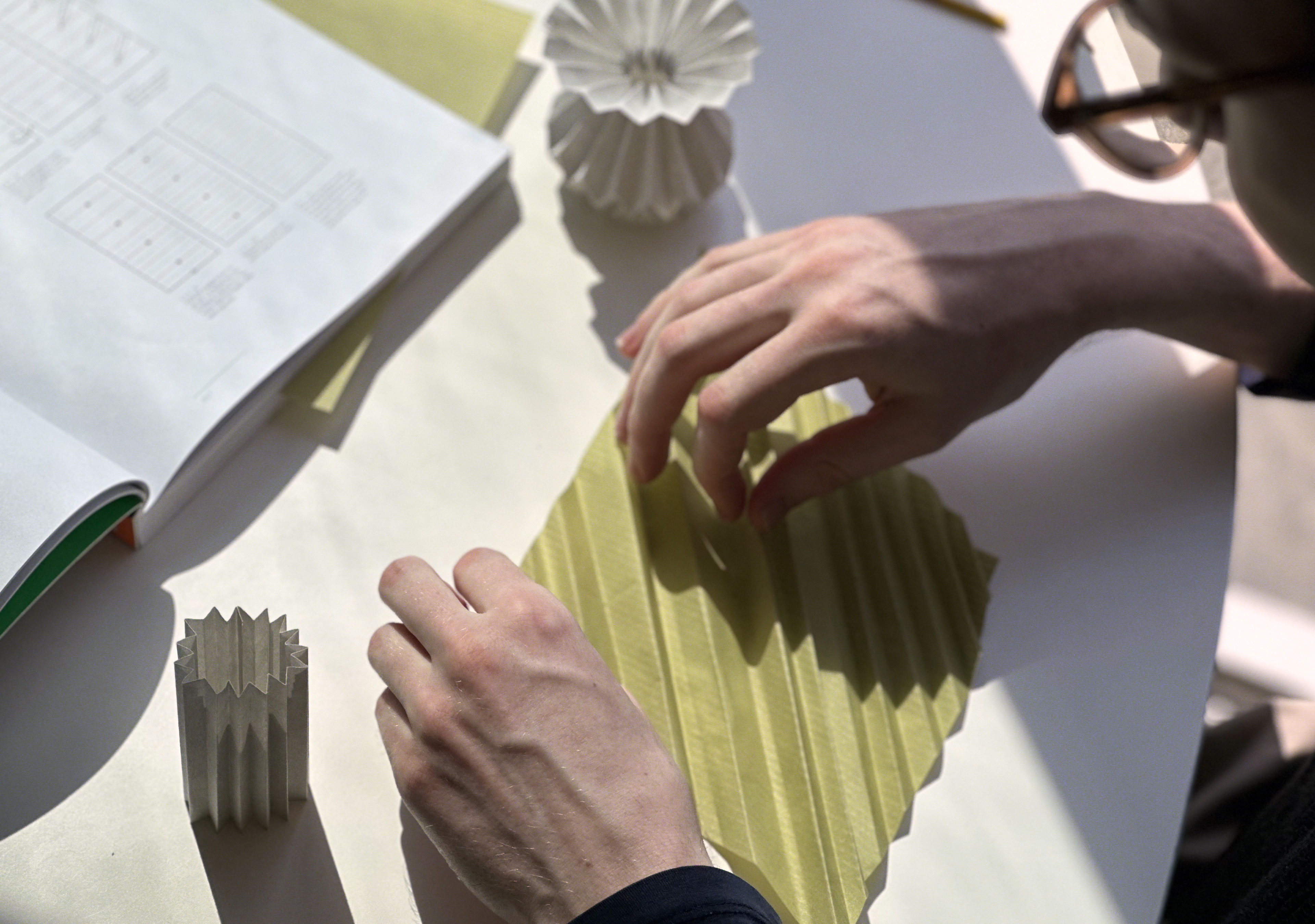 Paper folding study photographed on a desk.